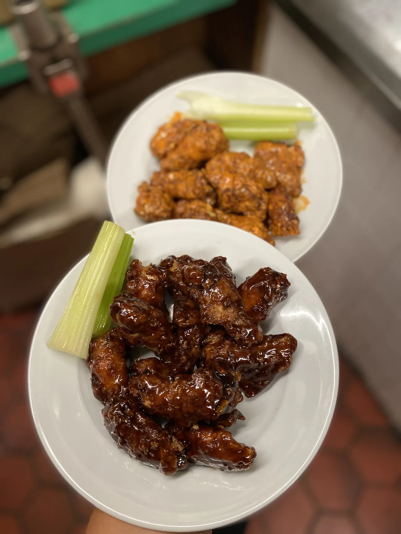 Two plates of wings with celery and dip